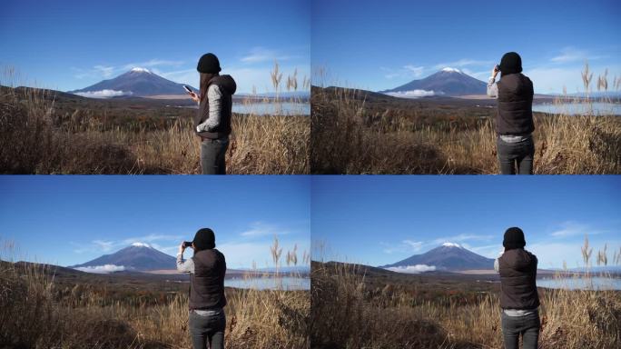 美丽的女人在拍福吉山的照片。