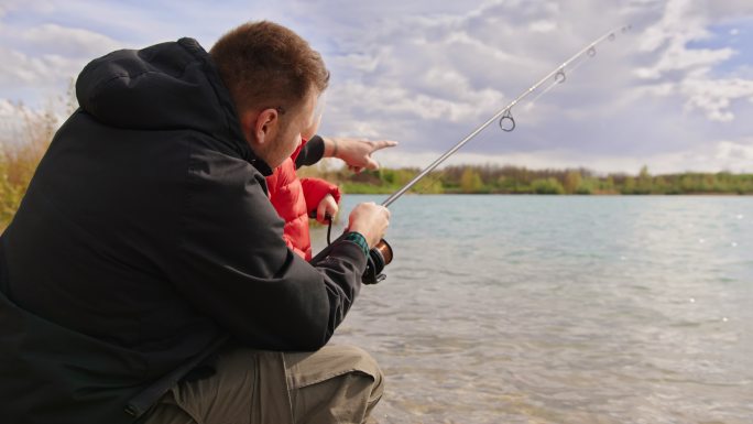 父亲教儿子在河里钓鱼