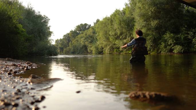 年轻的渔夫在河里钓鱼
