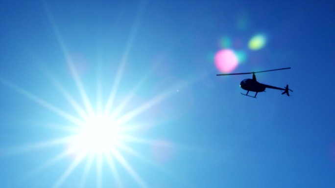 飞行中的直升机阳光直射天空飞机太阳光晕