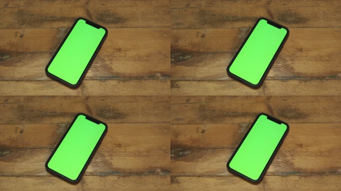 绿屏手机放在木制桌子上