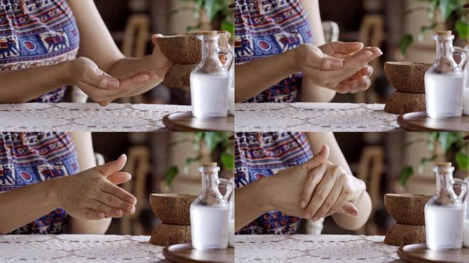 西班牙年轻女子用椰子油搓手作为皮肤保护的常规动作的慢镜头特写