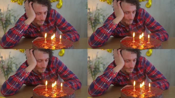 年轻悲伤的男人独自用生日蛋糕庆祝生日