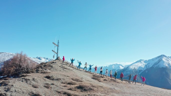 航拍一群人站在雪山对面的山坡上
