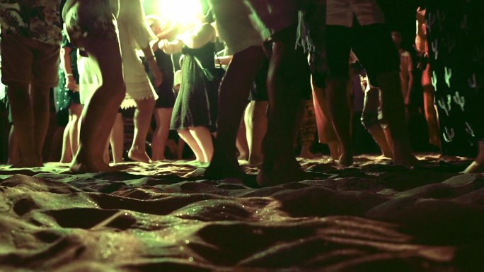 海滩派对上夜晚跳舞的人群