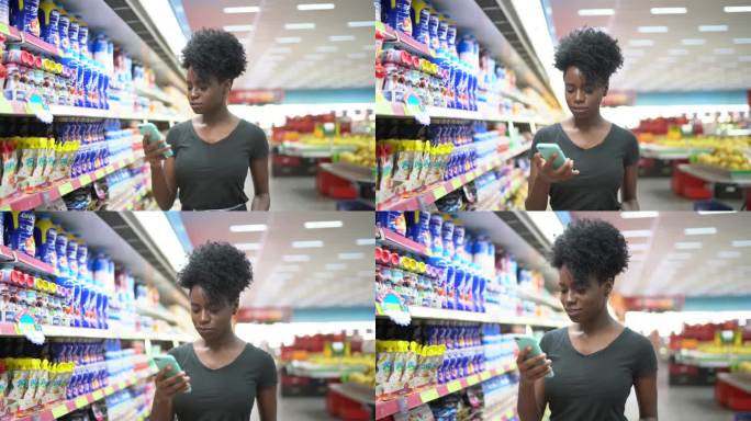 在超市使用手机和选择产品的年轻女性