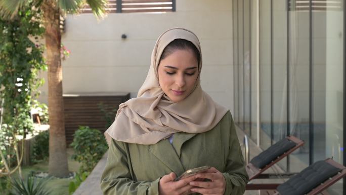 年轻的中东妇女在户外使用电话