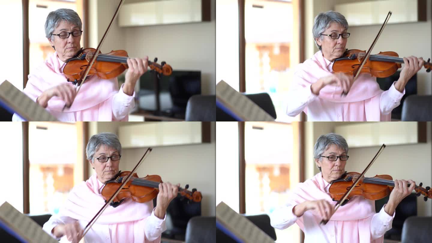 在家拉小提琴的老年妇女