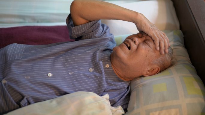 4K患病的亚洲老人在家中感到头痛