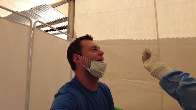 马拉维一名男子在帐篷里做新冠肺炎测试鼻子拭子