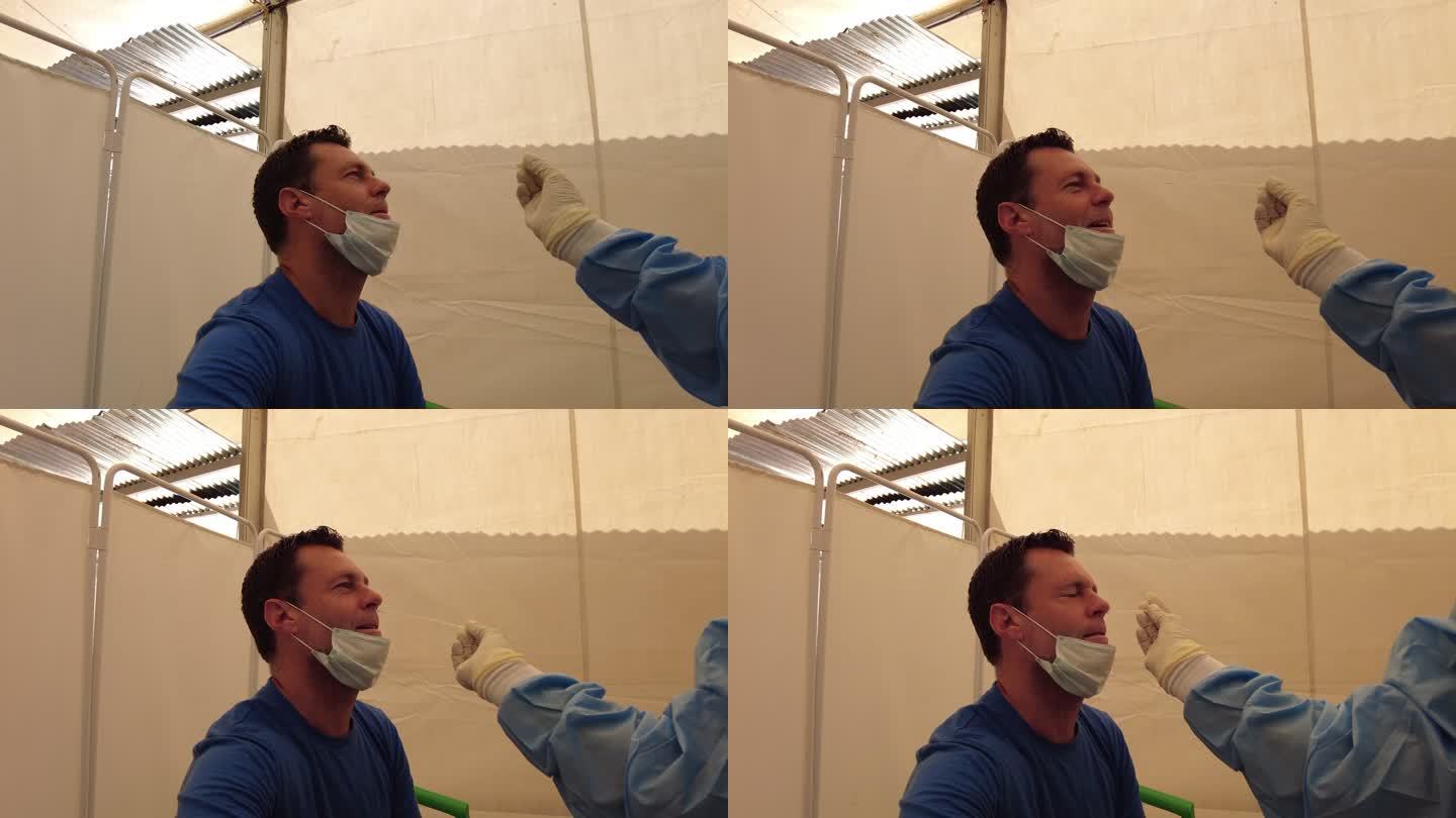 马拉维一名男子在帐篷里做新冠肺炎测试鼻子拭子