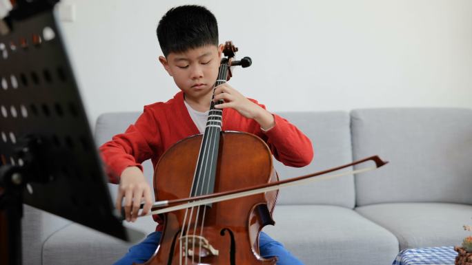 年轻男孩在家练习大提琴的全景