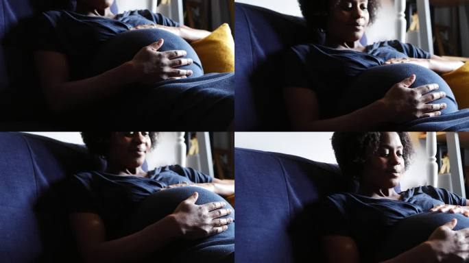 安静的孕妇在沙发上抚摸腹部放松