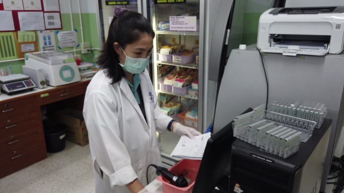 医疗技术人员正在献血室使用血液分析仪。