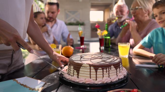 无法辨认的女人切生日蛋糕的特写