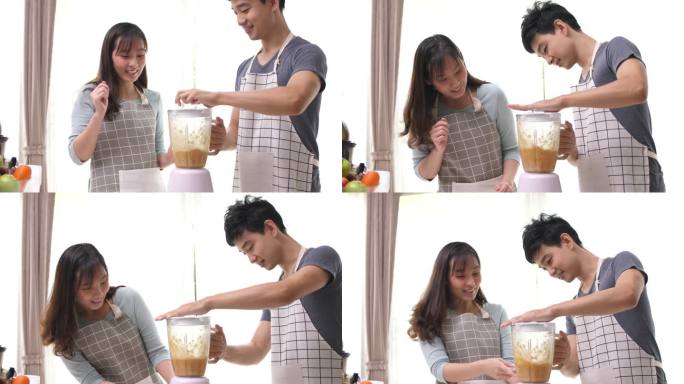 幸福的夫妇享受在厨房准备果汁