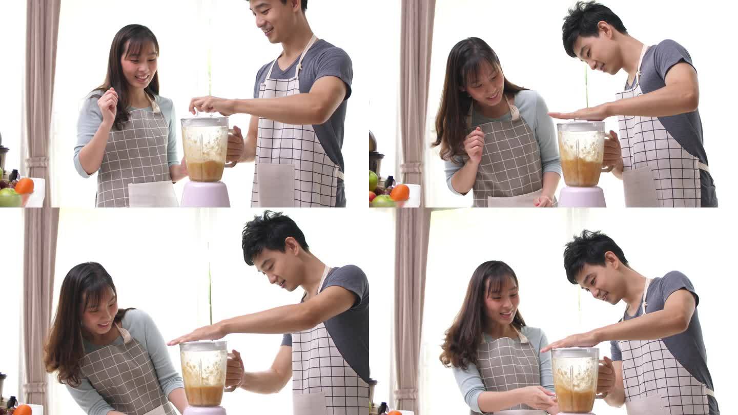 幸福的夫妇享受在厨房准备果汁