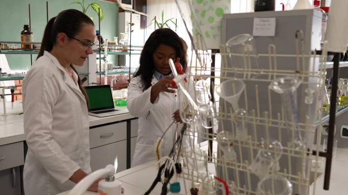 一群女化学家在实验室里分析液体溶液。