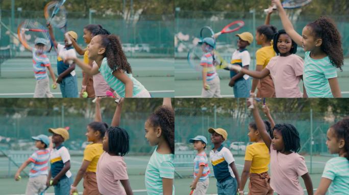 一群孩子在打网球。快乐、可爱、多样化的网球运动员站在一起，拿着球拍站在球场上