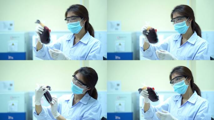 戴着防护眼镜的女科学家在实验室里摇晃着看着血袋