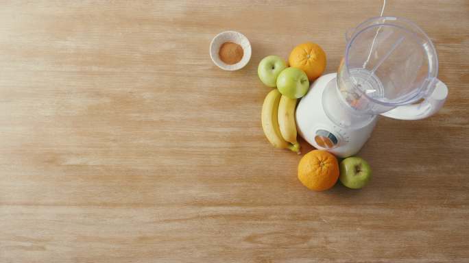 从搅拌机、玻璃杯、新鲜有机水果和坚果成分的上方放平，这些成分可用于健康排毒奶昔或有益健康的奶昔。能量