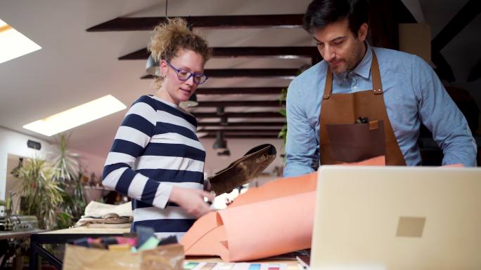 在裁缝的帮助下，女顾客选择包的材料和设计