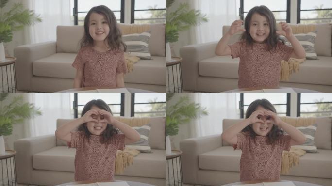 混合亚洲年轻女孩用双手捂住眼睛做心形手势，快乐志愿者，捐赠和慈善，家庭爱，心脏健康保险，心理健康理念