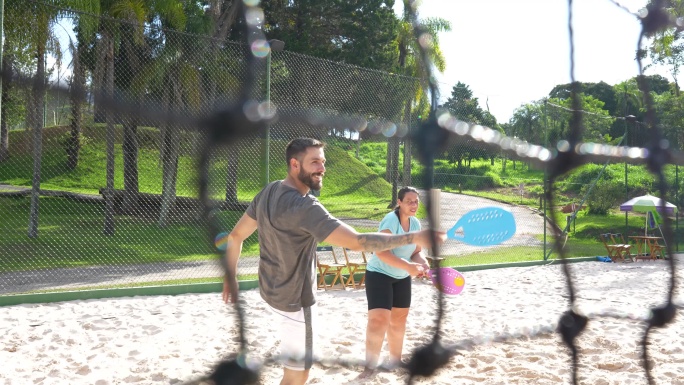情侣打沙滩网球爱人欢乐温馨家庭