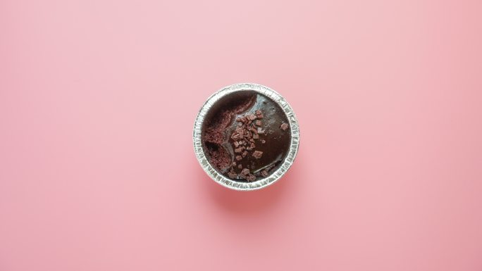 4k定格：在粉色背景下吃美味的巧克力杯蛋糕