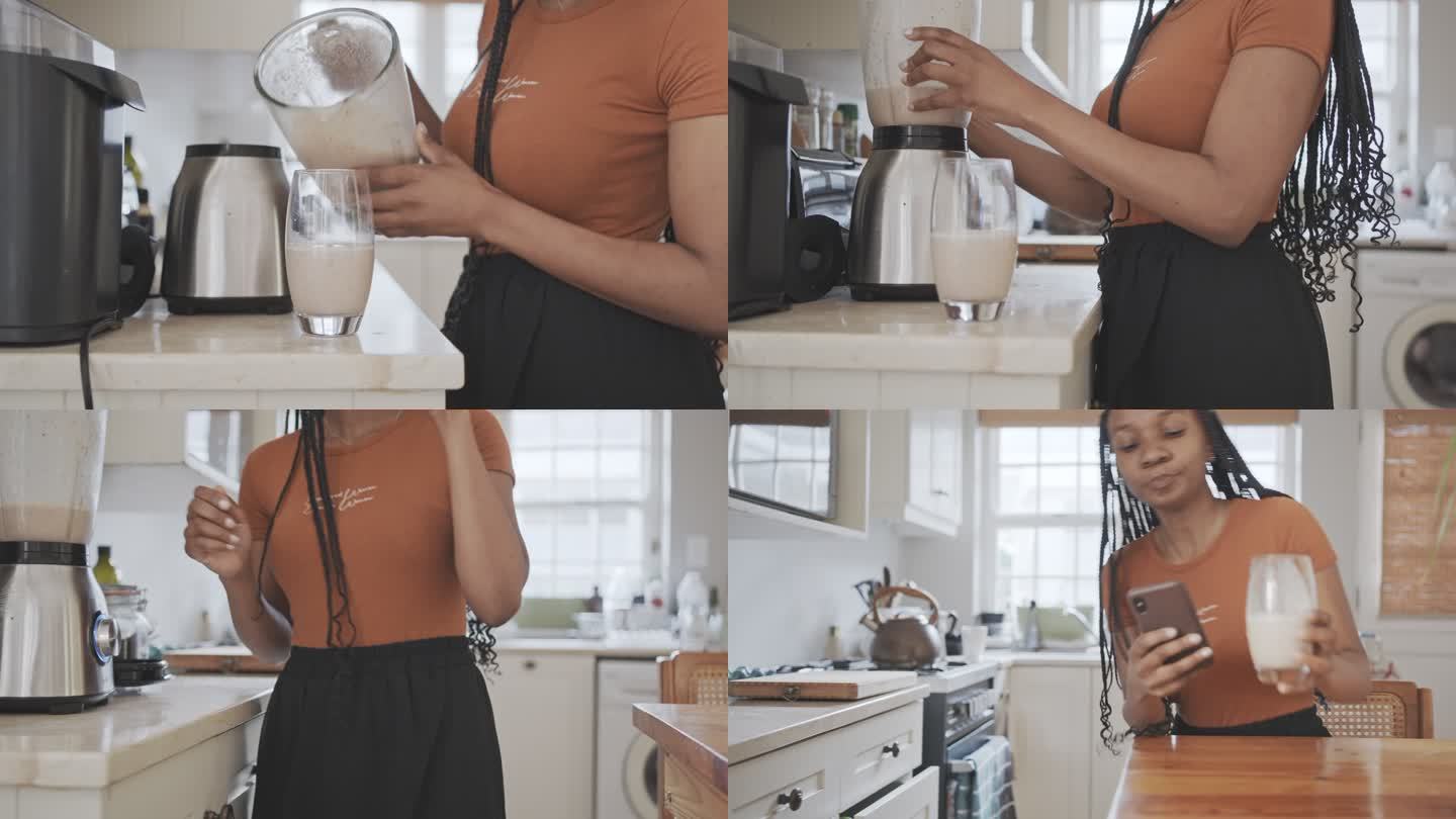一位女士在厨房检查手机时喝了一杯蛋白奶昔