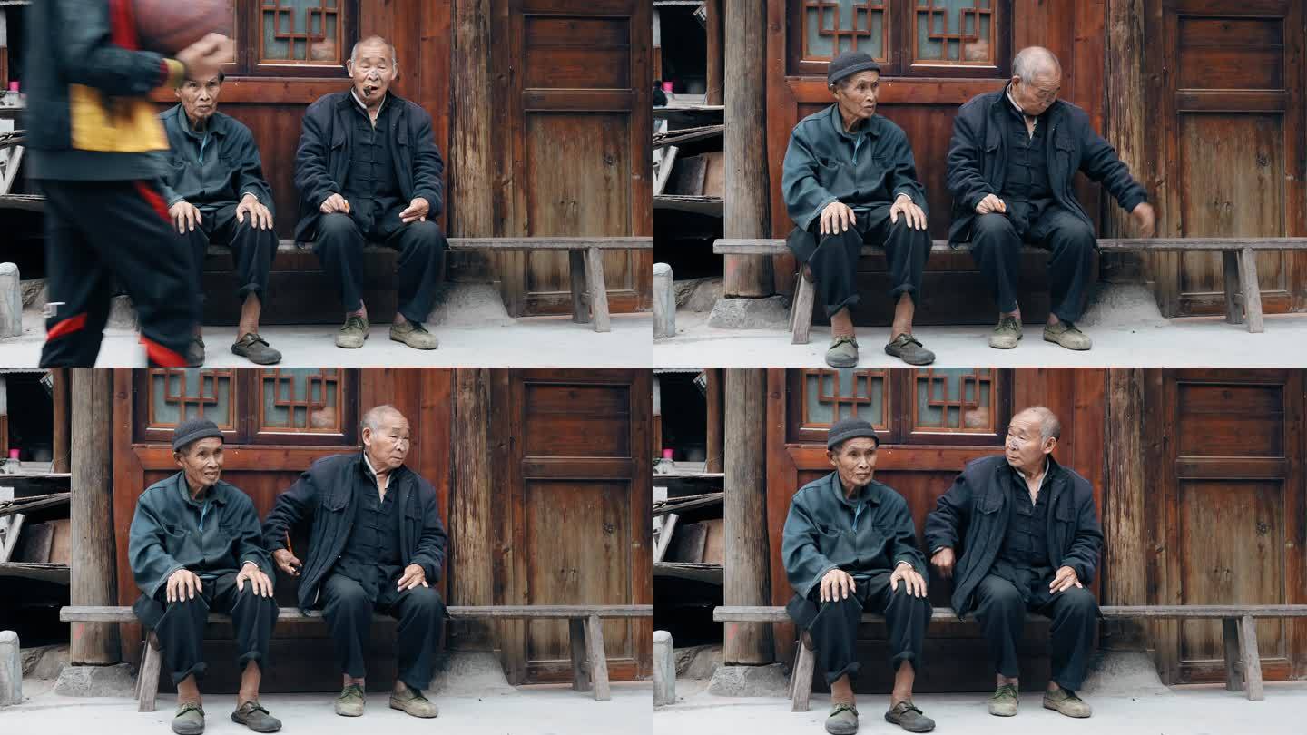 两名中国老年人坐在长椅上
