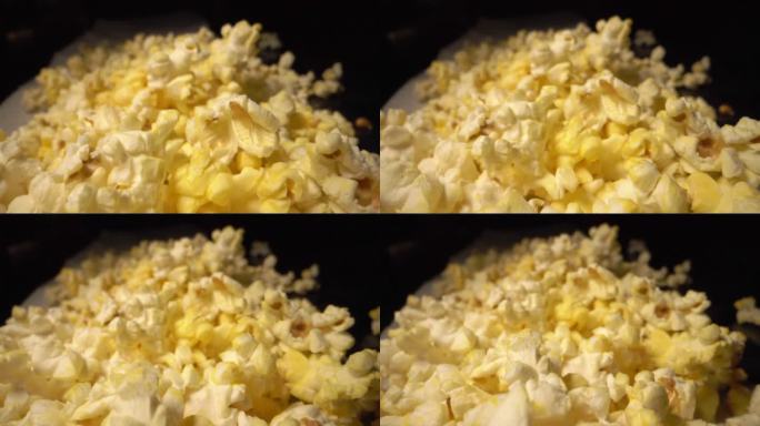 慢镜头移动相机广角移动拍摄柜台顶部的一堆新鲜奶油奶油黄色爆米花