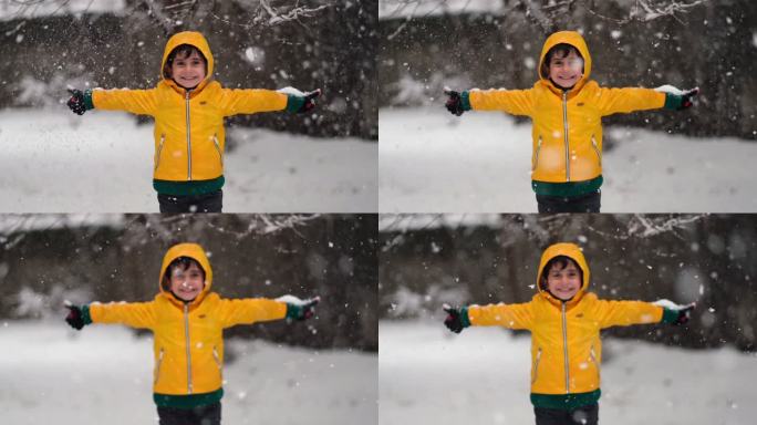 穿着黄色冬衣的有趣小男孩在下雪时散步。儿童户外冬季活动。