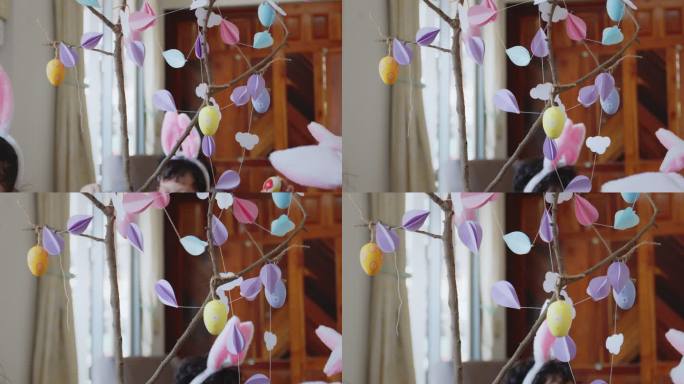 五颜六色的复活节彩蛋挂在树枝上，用花环装饰复活节假期。