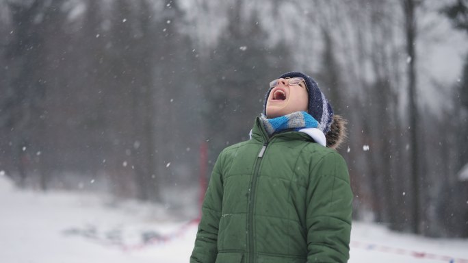 青少年男孩在冬天吃雪
