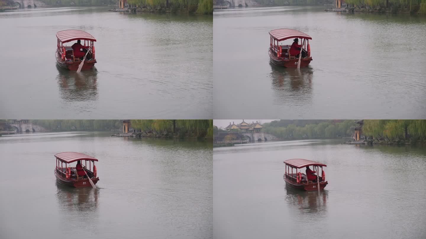 扬州瘦西湖阴雨天在雨中行驶中摇橹船船娘