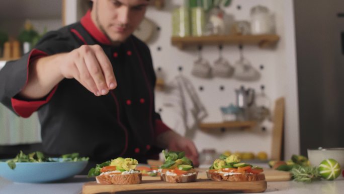 厨师在三明治上加一小撮葵花籽的选择性焦点镜头