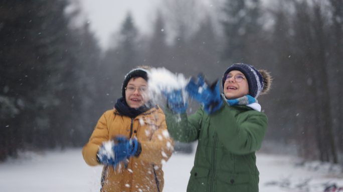 十几岁的男孩正在享受冬日的第一场雪
