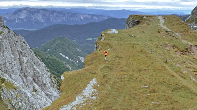 AERIAL男跑步者在美丽的环境中在高山上跑步