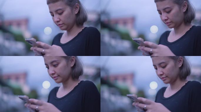 亚洲女性晚上使用智能手机在线文本聊天。