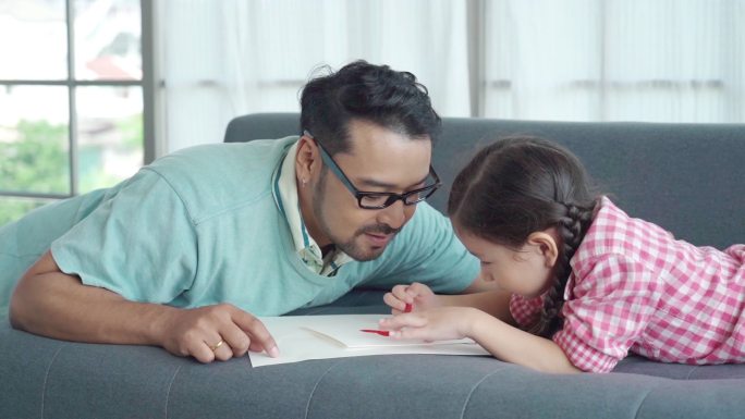 亚洲单身父亲在家照顾女儿，玩耍，教学，女孩制作父亲节问候演员，家庭教育理念
