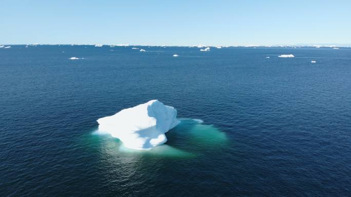 格陵兰岛阳光明媚的蓝色海洋表面上的冰山
