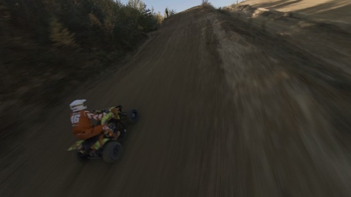 用赛车无人机射击沙雷。空旷、平坦的地形上覆盖着黄沙和重型机械履带