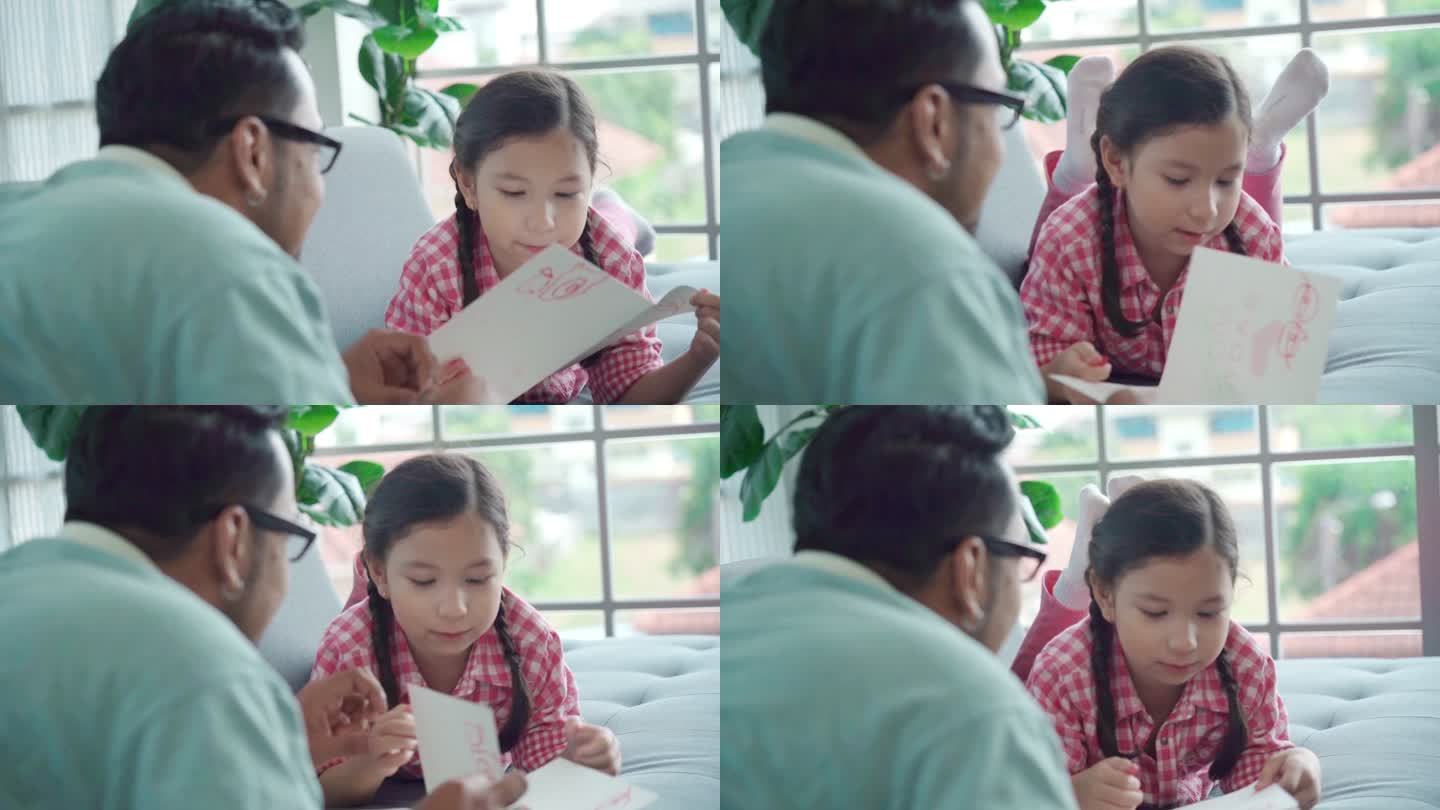 亚洲单身父亲在家照顾女儿，玩耍，教学，女孩制作父亲节问候演员，家庭教育理念