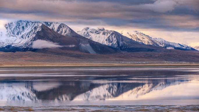 西藏的雪山倒映在湖面上，显得柔和而美丽
