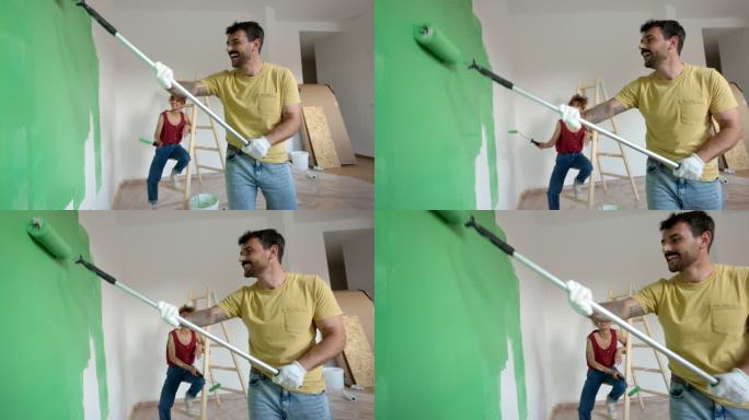 一对幸福的夫妇在粉刷他们的新公寓