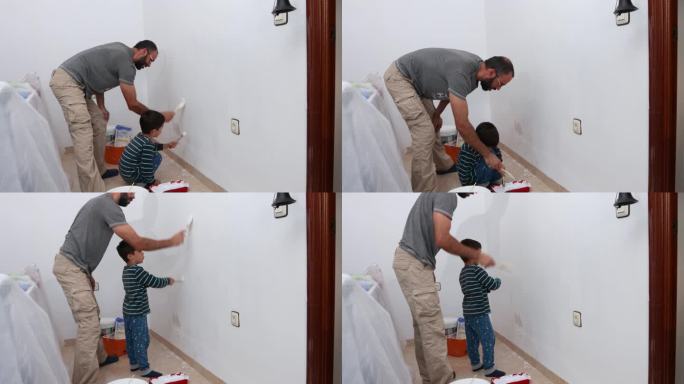 父子俩粉刷白房子的墙壁