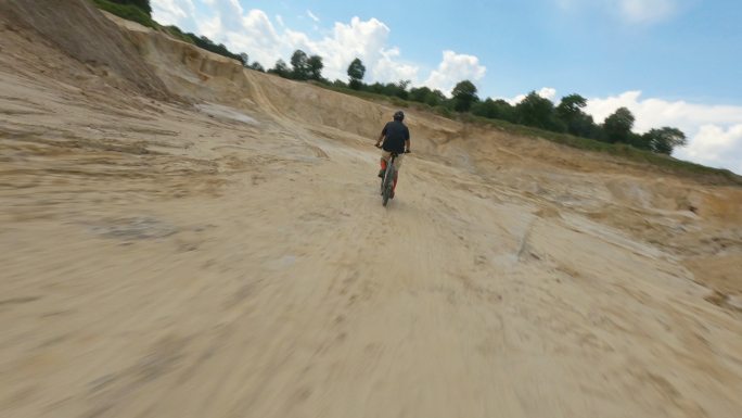 用赛车无人机拍摄沙矿。空旷、平坦的地形上覆盖着黄沙和厚重的机械痕迹