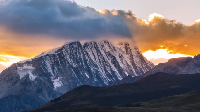 夕阳把雪山顶上的云染成了红色