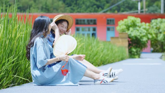 坐在绿色稻田里边的美少女闺蜜聊天玩耍乡村